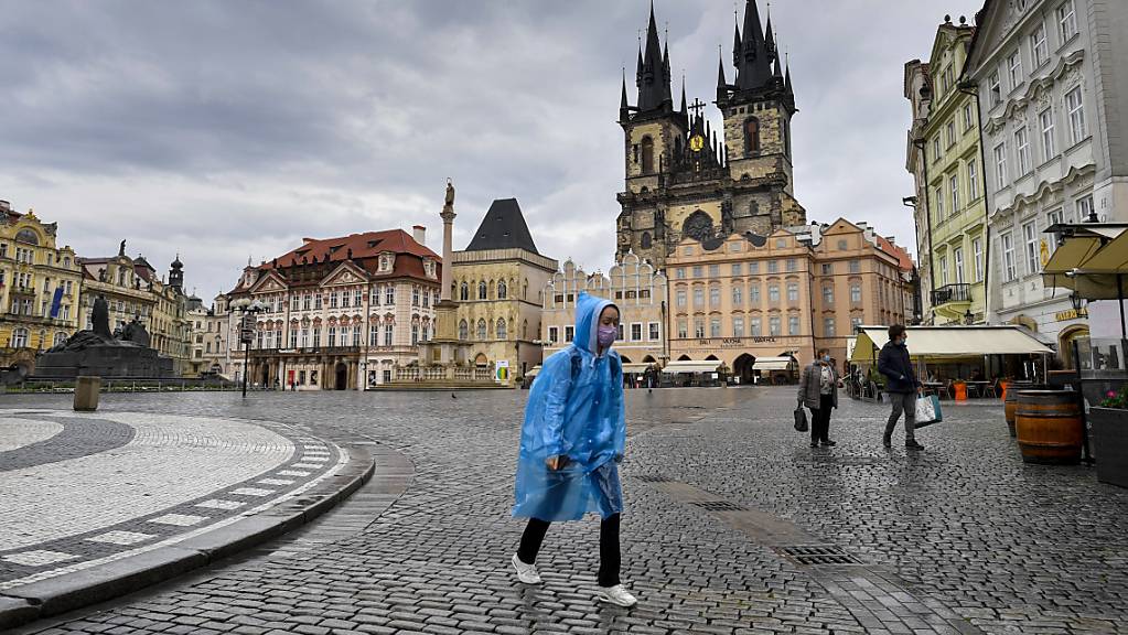  Frau geht bei Regen durch die fast menschenleere Altstadt von Prag.