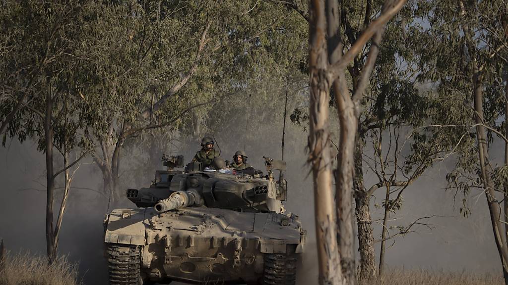 ARCHIV - Israelische Soldaten bewegen sich auf einem Panzer in der Nähe der Grenze zwischen Israel und Gaza. Foto: Leo Correa/AP/dpa