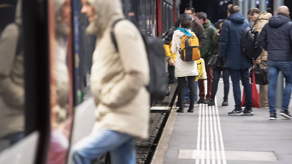 Pendler steigen in einen Zug ein am Bahnhof in Bellinzona. Ab März fahren mehr Züge durch den Gotthard-Basistunnel. (Archivbild)