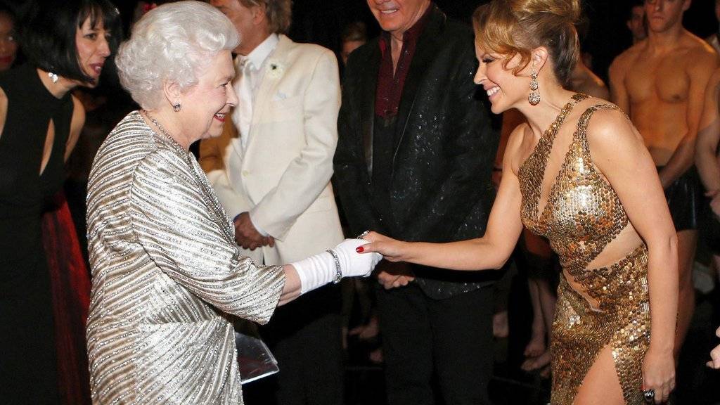 Queen Elizabeth II. (l) und Kylie Minogue (r) - hier 2012 nach einer Show in der Royal Albert Hall - sehen sich bald wieder: Minogue gehört zu den Künstlern, die der Königin am 15. Mai in einer Fernsehshow zum 90. Geburtstag gratulieren. (Archivbild)