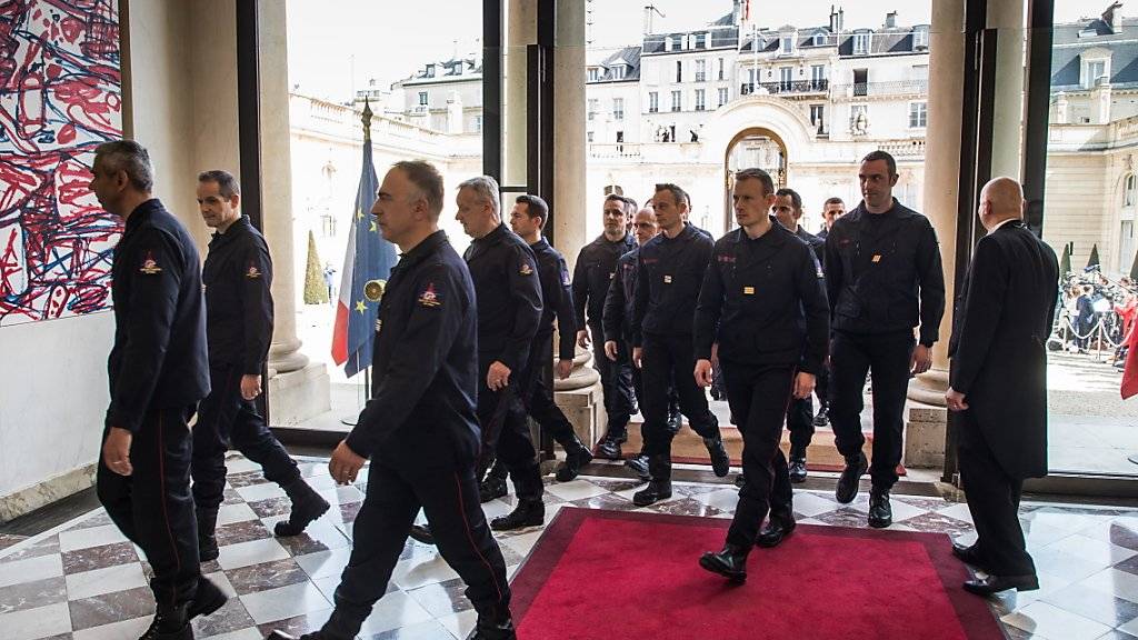 Die Feuerwehrleute treten in den Elysée-Palast ein.