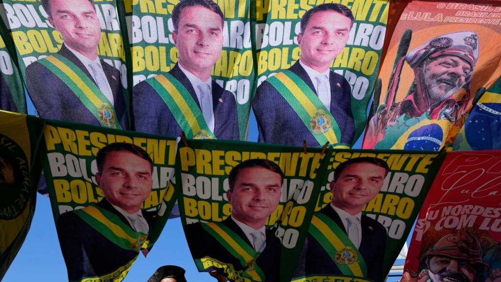 ARCHIV - Ein Straßenhändler verkauft Wahlkampf-Fahnen der Präsidentschaftskandidaten Bolsonaro und des amtierenden Präsidenten Lula da Silva, der sich um eine Wiederwahl bewirbt. Foto: Eraldo Peres/AP/dpa