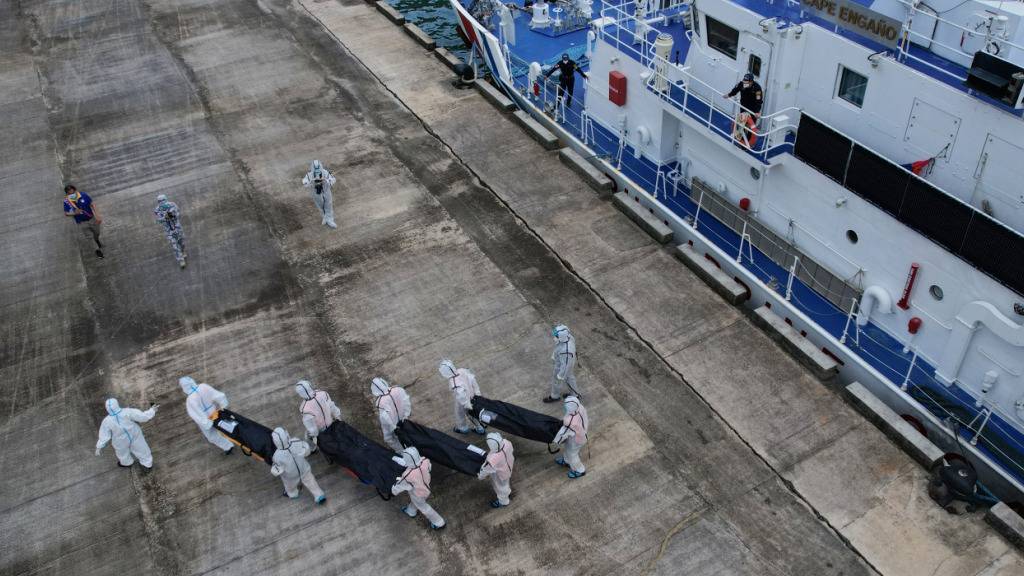 Rettungskräfte tragen die sterblichen Überreste der Opfer des jüngsten Brandes auf der Fähre «MV June Aster» von Bord eines Schiffes der philippinischen Küstenwache im Hafen von Borac in Coron. Foto: Aaron Favila/AP/dpa