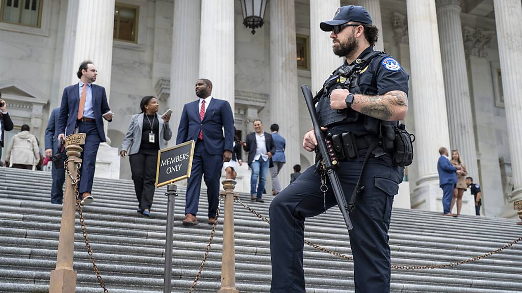 dpatopbilder - Ein Beamter der U.S. Capitol Police beobachtet, wie Gesetzgeber das Repräsentantenhaus verlassen. Foto: J. Scott Applewhite/AP/dpa