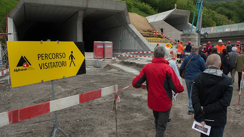 Besucher mit Schutzhelmen machen sich am Tunnelportal bereit für die Besichtigung im Ceneri Tunnel. (Archivbild)