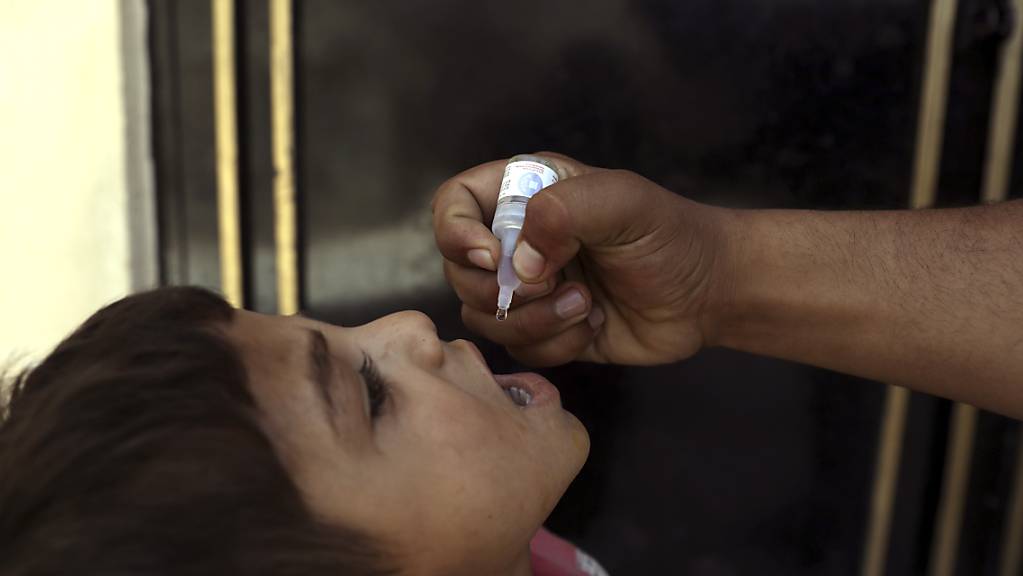 ARCHIV - Ein Mitarbeiter des Gesundheitswesens in Kabul verabreicht einem Kind eine Polio-Impfung. Foto: Rahmat Gul/AP/dpa