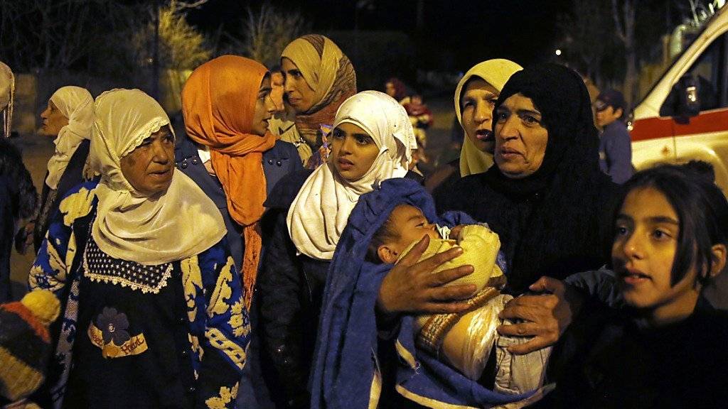 Frauen und Kinder warten auf die Hilfslieferungen in der besetzten Stadt Madaja.