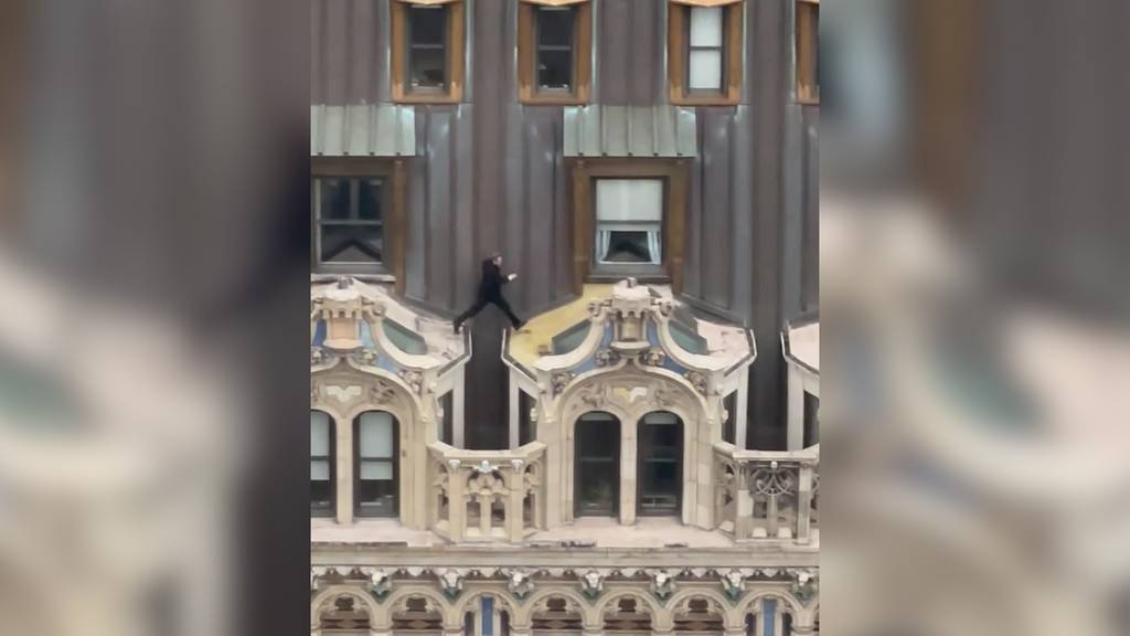 Mann im Anzug springt über Hochhaus-Dach in New York