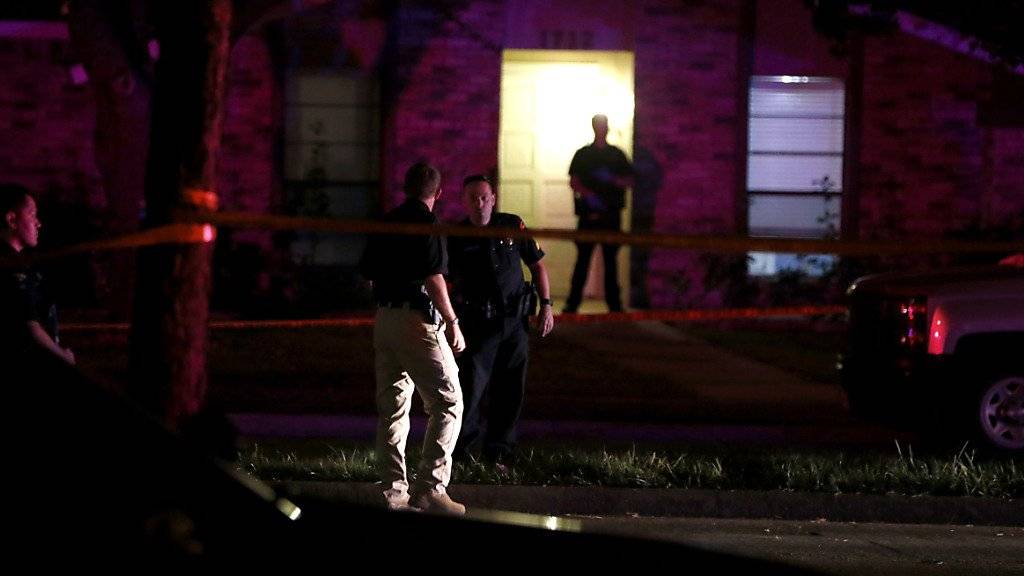 Polizisten untersuchen das Haus, in dem sieben Menschen durch die Waffe eines Mannes ums Leben gekommen sind. Der Täter wurde später von der Polizei erschossen.