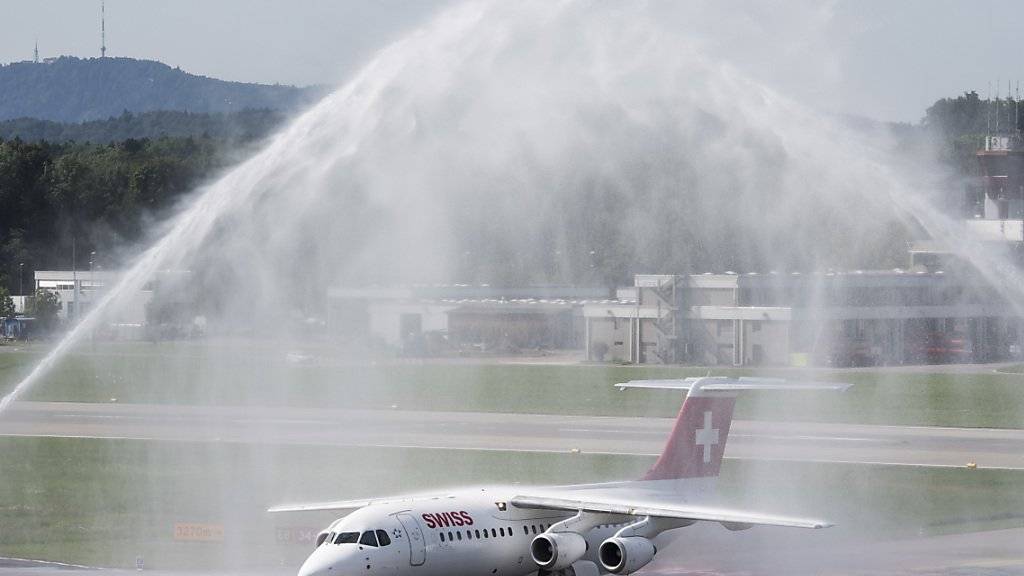 Eine Wasserfontäne zum Abschied: Der Avro RJ100 Jumbolino nach seinem letzten Flug von Genf nach Zuerich. (KEYSTONE/Ennio Leanza)