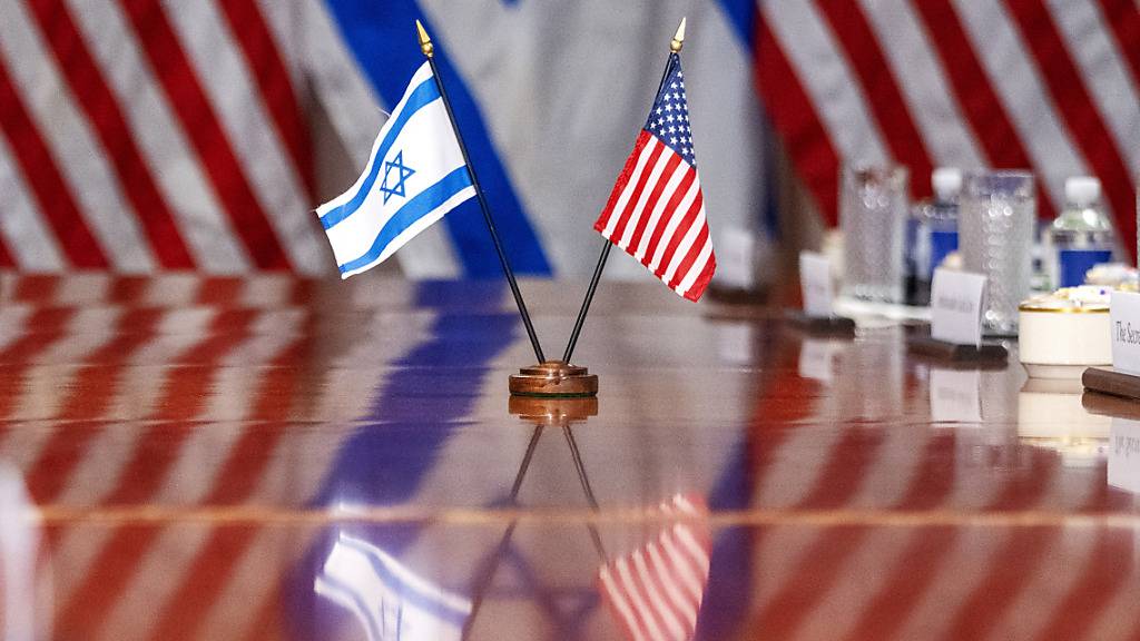 Eine israelische und eine US-Flagge spiegeln sich auf einem Konferenztisch: US-Verteidigungsminister Austin hat seinen israelischen Amtskollegen Galant im Pentagon empfangen. Foto: Jacquelyn Martin/AP/dpa