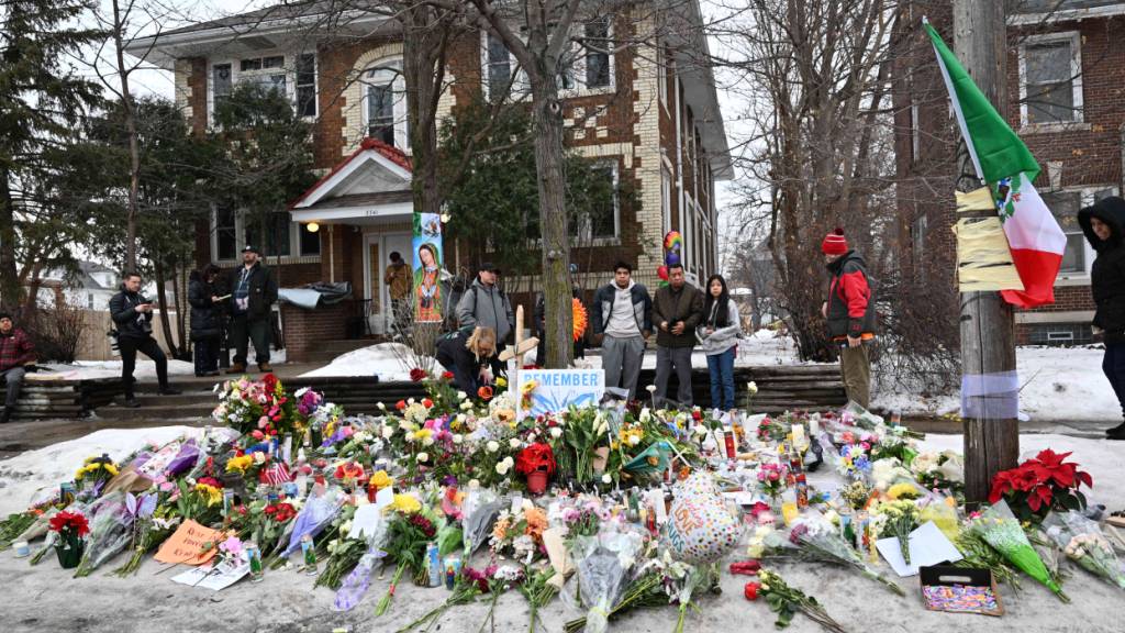 dpatopbilder - Menschen versammeln sich um eine behelfsmäßige Gedenkstätte zu Ehren des Opfers tödlicher Schüsse durch Bundespolizisten in der Nähe des Tatortes. Foto: Tom Baker/AP/dpa - ACHTUNG: Nur zur redaktionellen Verwendung und nur mit vollständiger Nennung des vorstehenden Credits