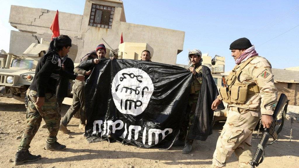 Irakische Soldaten mit einer konfiszierten IS-Flagge. (Archivbild)