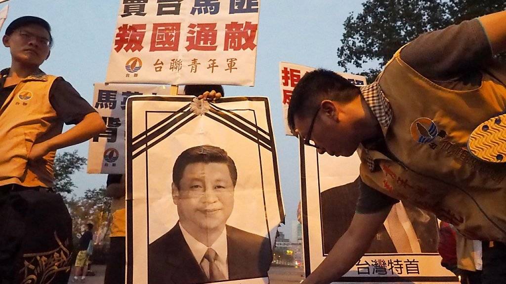 Unabhängigkeitsbefürworter in Taiwan zünden ein Portrait von Staatschef Ma Ying Jeou an aus Protest gegen dessen Treffen mit Chinas Präsidenten.