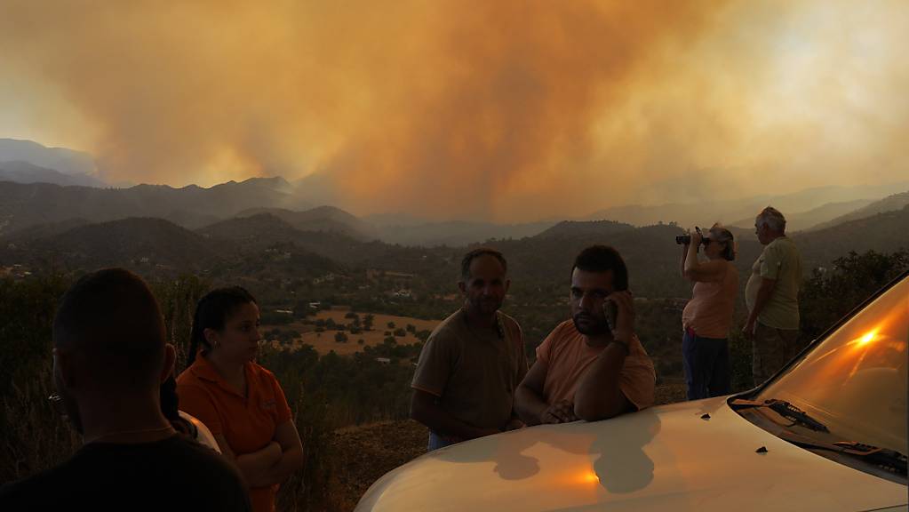 Anwohner beobachten ein Feuer in der Bergregion von Larnaca.