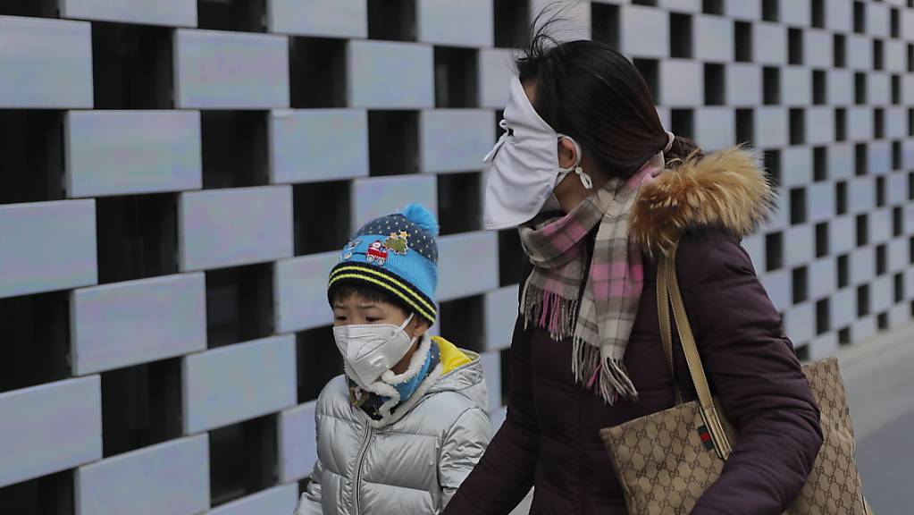 Die durch das Coronavirus hervorgerufene Lungenkrankheit aus China verbreitet sich weiter - überall auf der Welt schützen sich Menschen mittlerweile wie hier im Bild in Peking mit Schutzmasken.