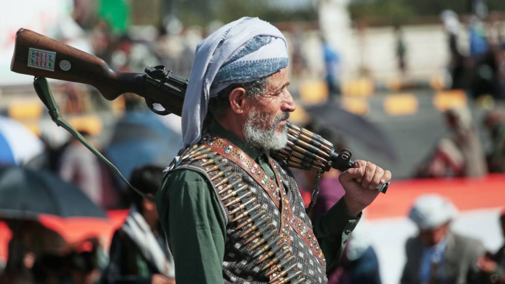 Ein Anhänger der jemenitischen Huthi-Rebellen trägt sein Gewehr während einer Kundgebung zur Unterstützung der Gruppe. Foto: Osamah Abdulrahman/AP/dpa
