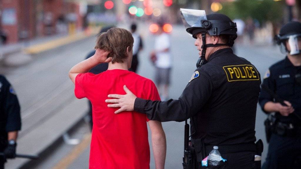 Ein Trump-Anhänger wird von Polizisten in Sicherheit geführt, nachdem Trump-Gegner einen Wahlkampfauftritt des populistischen republikanischen Präsidentschaftsanwärters im kalifornischen San José gestürmt hatten.