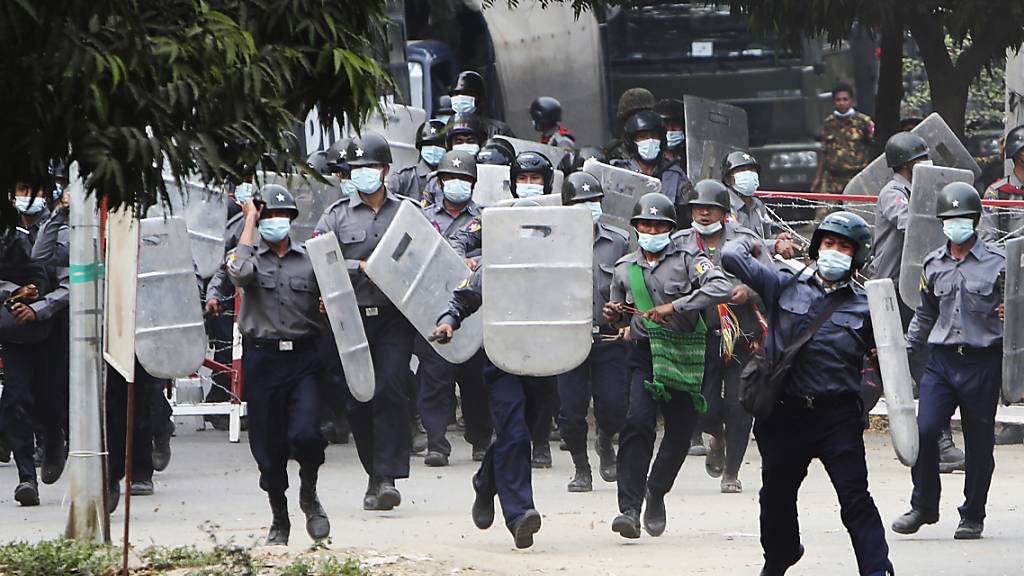Polizisten stürmen auf Demonstranten zu, um sie zu vertreiben. Foto: --/AP/dpa