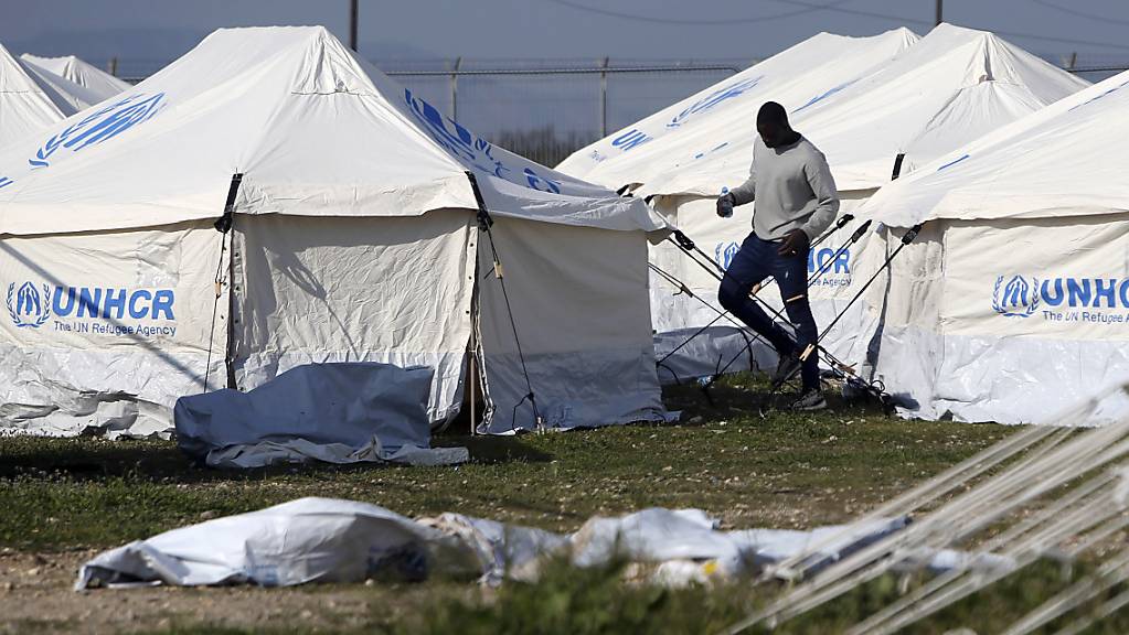 ARCHIV - Ein Mensch geht an den Zelten in einem Flüchtlingslager auf Zypern vorbei. Das EU-Mitgliedsland Zypern hat erneut ankommende Migranten zurückgeschickt. Foto: Petros Karadjias/AP/dpa