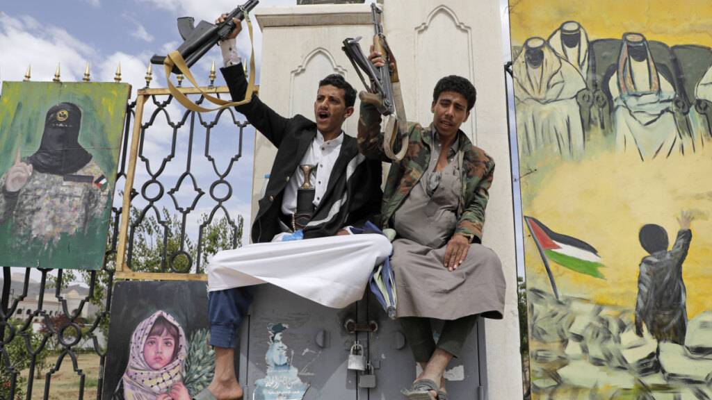 ARCHIV - Huthi-Anhänger skandieren während einer Anti-USA- und Anti-Israel-Kundgebung Slogans vor Transparenten zur Unterstützung der Palästinenser. Foto: Osamah Abdulrahman/AP/dpa