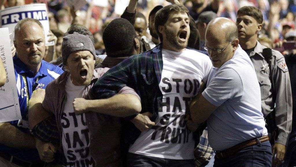 Sicherheitsleute entfernen Protestierende bei einer Veranstaltung des populistischen Präsidentschaftsbewerbers Donald Trump in Fayetteville, North Carolina. Bei der Veranstaltung wurde auch ein Schwarzer von einem Trump-Anhänger geschlagen.