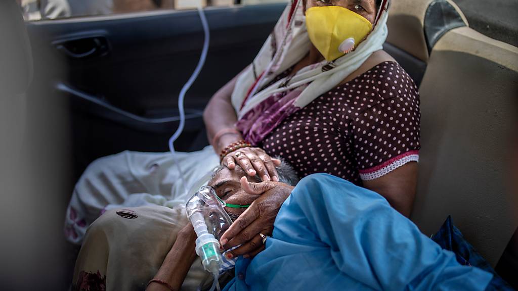 Ein Patient atmet mit Hilfe von Sauerstoff in einem Auto in Neu-Delhi. In Indien hat es den fünften Tag in Folge einen weltweiten Rekord bei den Corona-Neuinfektionen gegeben. Foto: Altaf Qadri/AP/dpa