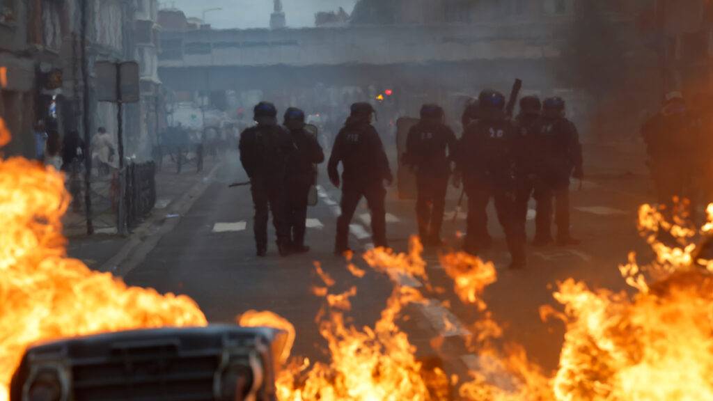 dpatopbilder - Französische Polizisten stehen vor brennendem Müll, während Schülerinnen und Schüler für mehr Mittel und mehr Personal demonstrieren. Seit Tagen protestieren Schülerinnen und Schüler an den Oberschulen. Foto: Jean-Francois Badias/AP/dpa