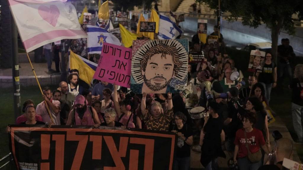 Angehörige und Unterstützer von israelischen Geiseln, die im Gazastreifen festgehalten werden, halten ein Transparent mit der Bitte um Hilfe in der Hand. Foto: Mahmoud Illean/AP/dpa