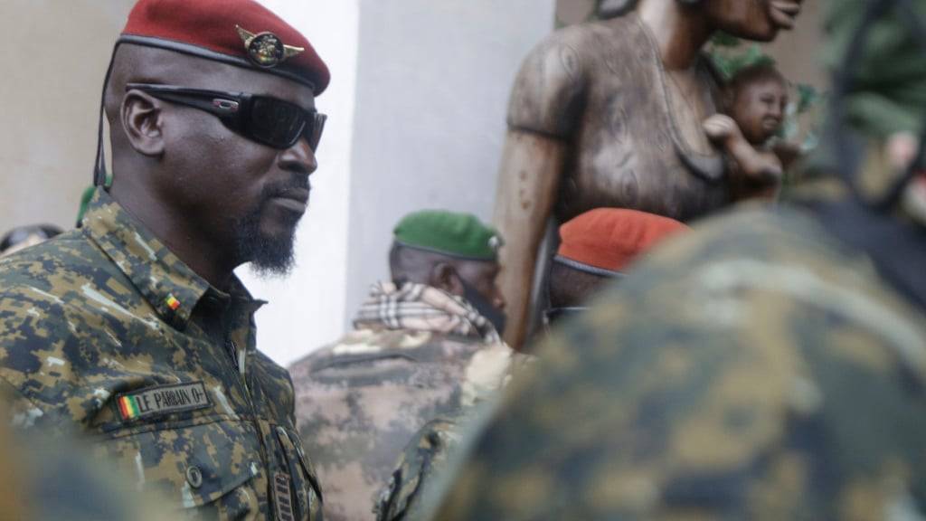 ARCHIV - Oberst Mamady Doumbouya, damals Kommandeur der Spezialeinheit der Armee, trägt eine rote Baskenmütze und eine Sonnenbrille, während er, nach einem Treffen mit einer Delegation der Westafrikanische Wirtschaftsgemeinschaft (ECOWAS), von Soldaten umgeben ist. Foto: Sunday Alamba/AP/dpa