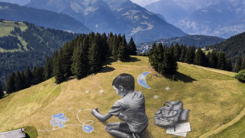 Der Land-Art-Künstler Saype hat oberhalb des waadtländischen Villars-sur-Orllon zwei riesige Bilder direkt ins Gras gezeichnet, die je nach Wetter schon bald wieder verschwinden werden. Die Gemälde thematisieren die Beziehung von Kindern zur Natur.