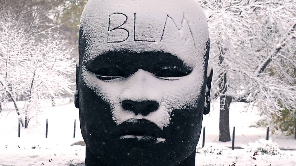 ARCHIV - «BLM» steht auf der verschneiten Stirn der Skulptur «Eternal Presence» vor dem «National Center of Afro-American Artists» geschrieben. Die Abkürzung «BLM» steht für die Menschenrechtsbewegung «Black Lives Matter». Foto: Charles Krupa/AP/dpa