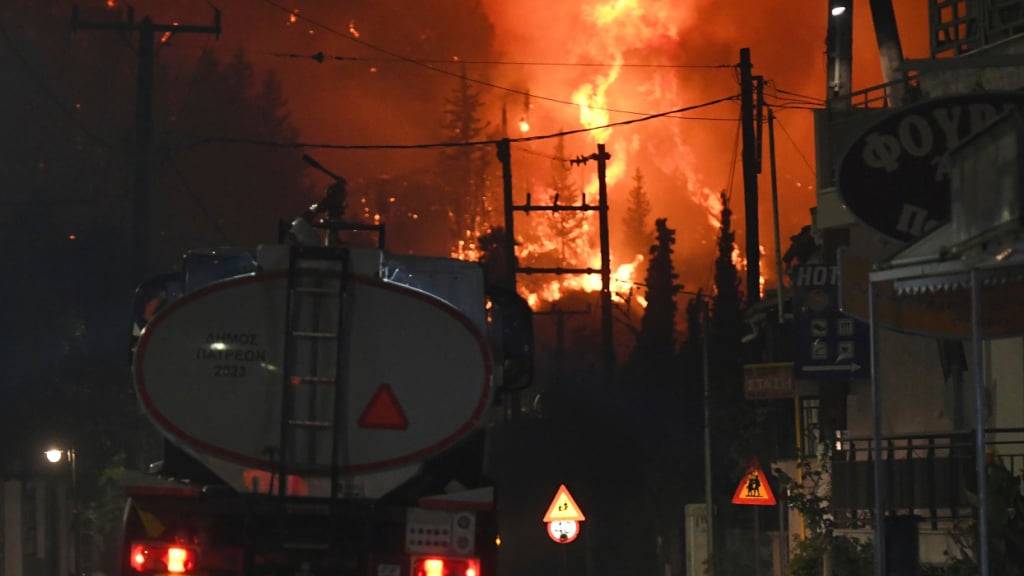 dpatopbilder - Bei einem Waldbrand im Dorf Kaminia in der Nähe von Patras schlagen Flammen aus einem Wald. Foto: Giannis Androutsopoulos/AP/dpa
