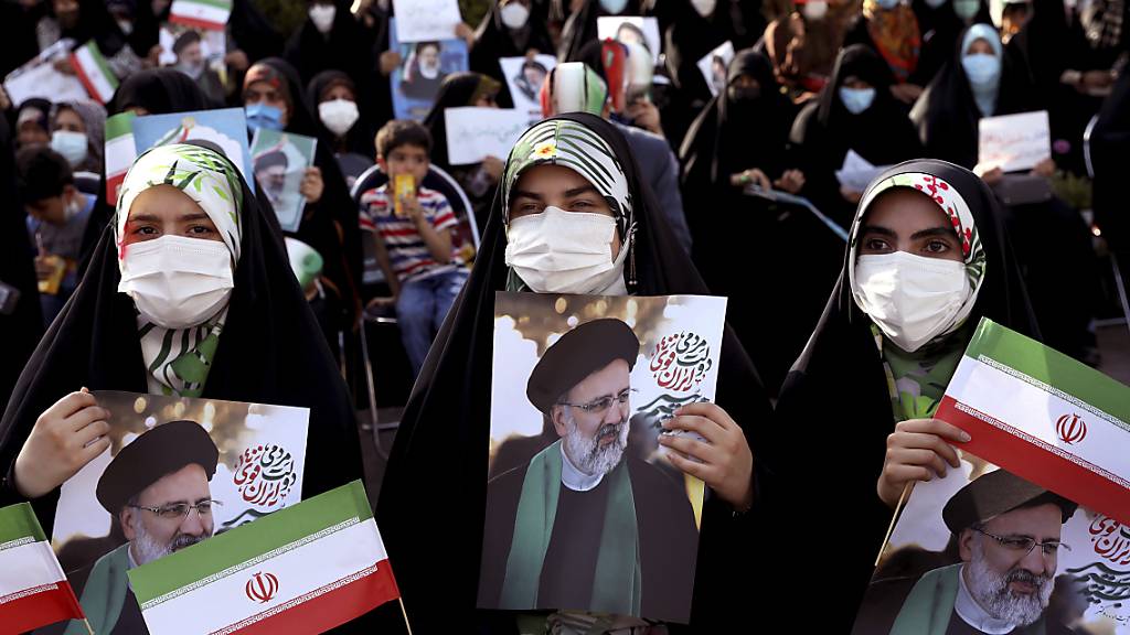 Unterstützerinnen des Präsidentschaftskandidaten Ebrahim Raisi halten während einer Demonstration für ihn Fotos von ihm. Foto: Ebrahim Noroozi/AP/dpa