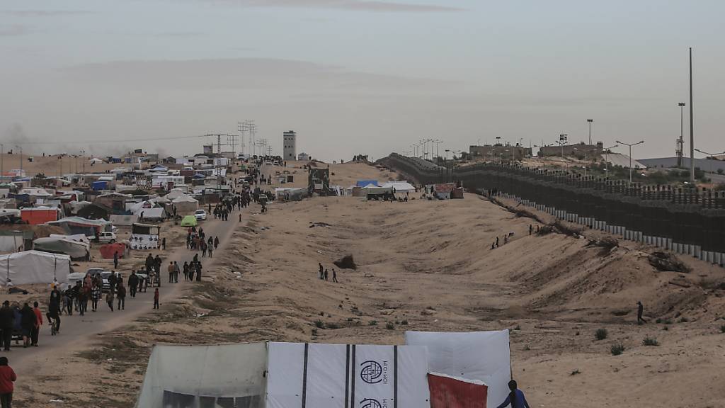 Vertriebene Palästinenser haben ihr Lager an der Mauer aufgeschlagen, die Ägypten und den Gazastreifen trennt. Foto: Mohammed Talatene/dpa
