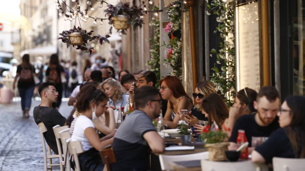 Touristen sitzen im Aussenbereich eines Restaurants in Rom: Schon bald soll das auch wieder in ganz Italien möglich werden. In vielen Regionen des Landes werden die Corona-Regeln entschärft.