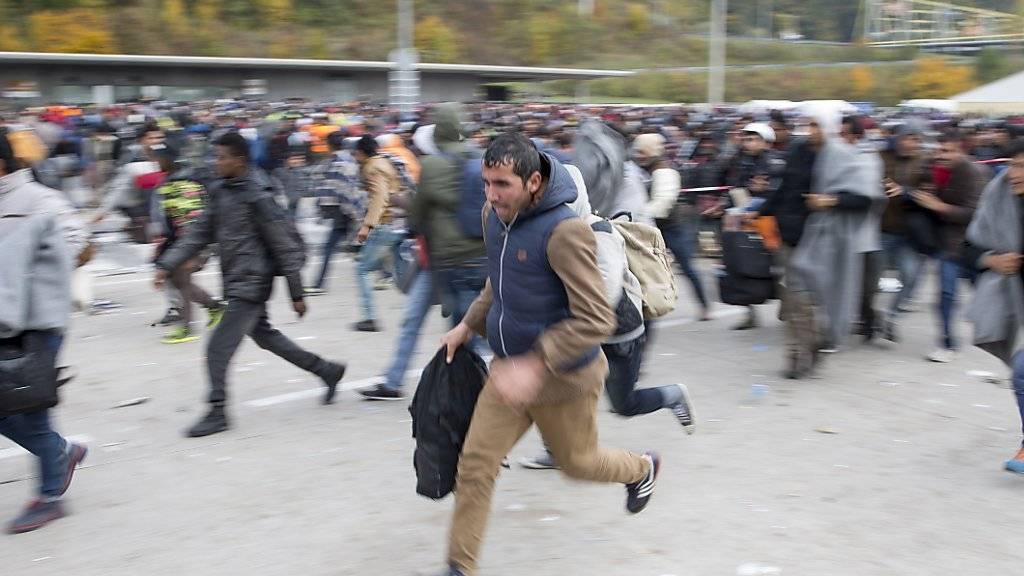 Flüchtlinge überqueren Absperrungen im Sammelzentrum an der Slowenisch-Österreichischen Grenze