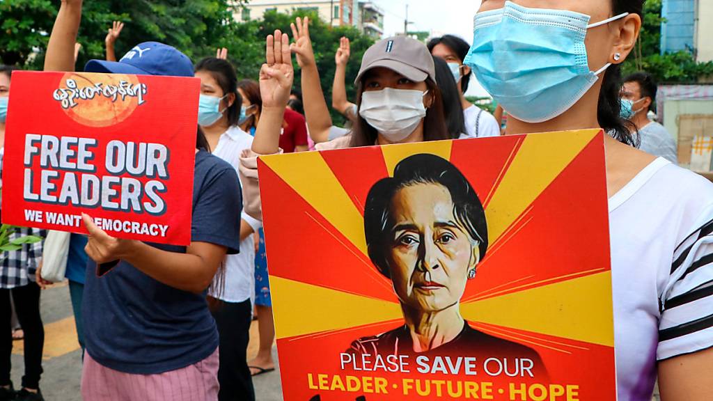 Anti-Putsch-Demonstranten in Yangon halten ein Plakat mit dem Bild der festgesetzten Regierungschefin Aung San Suu Kyi hoch. (Archivbild) Foto: Uncredited/AP/dpa