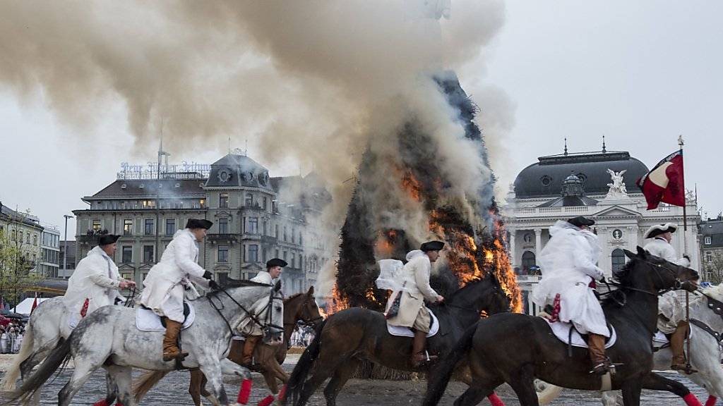 Reiter einer Zunft galoppieren am Sechseläuten in Zürich um den brennenden «Böögg». (Archivbild)