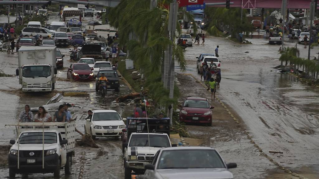 dpatopbilder - Autos überqueren eine überschwemmte Straße, nachdem Hurrikan Otis über Acapulco, Mexiko, hinweggefegt ist. Foto: Marco Ugarte/AP