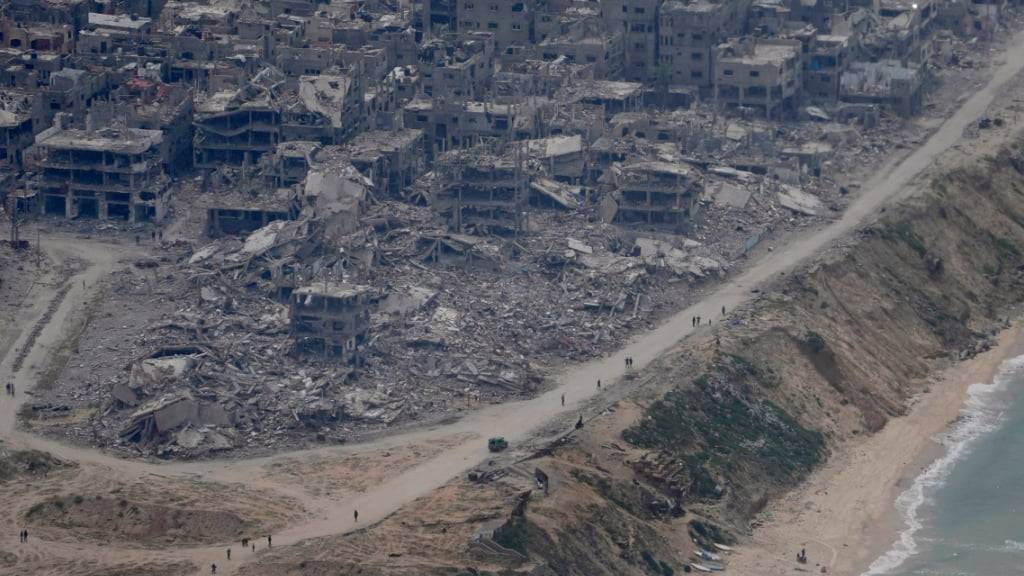Zerstörte Gebäude im Gazastreifen sind durch das Fenster eines C-17-Flugzeugs der US-Luftwaffe zu sehen. Foto: Hussein Malla/AP/dpa