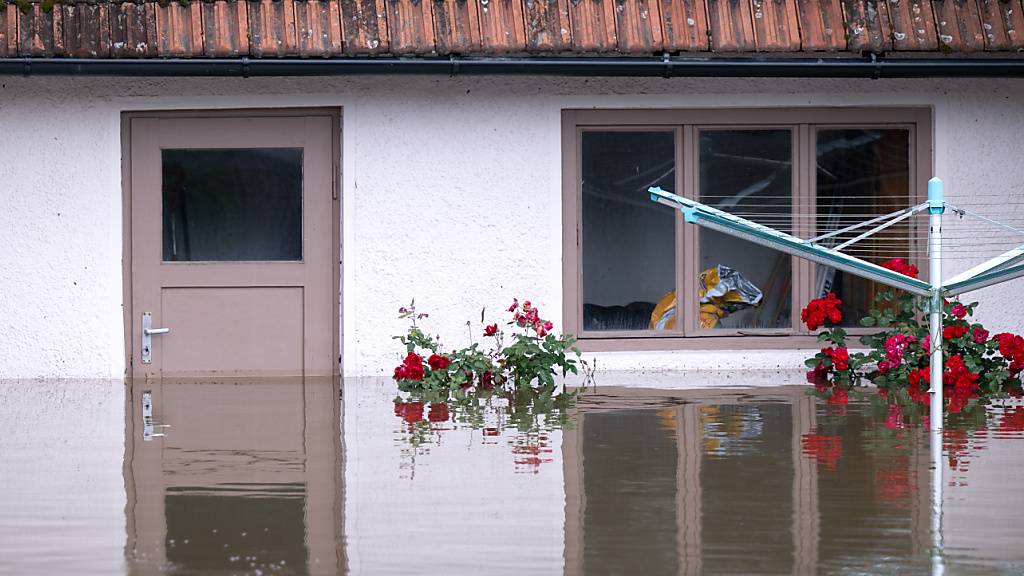 Ein Wäscheständer steht in einem überfluteten Garten von einem Wohnhaus im bayrischen Reichertshofen. Foto: Sven Hoppe/dpa