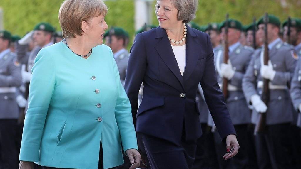 Bundeskanzlerin Merkel (links) schreitet mit der neuen britischen Premierministerin May die Ehrengarde in Berlin ab.