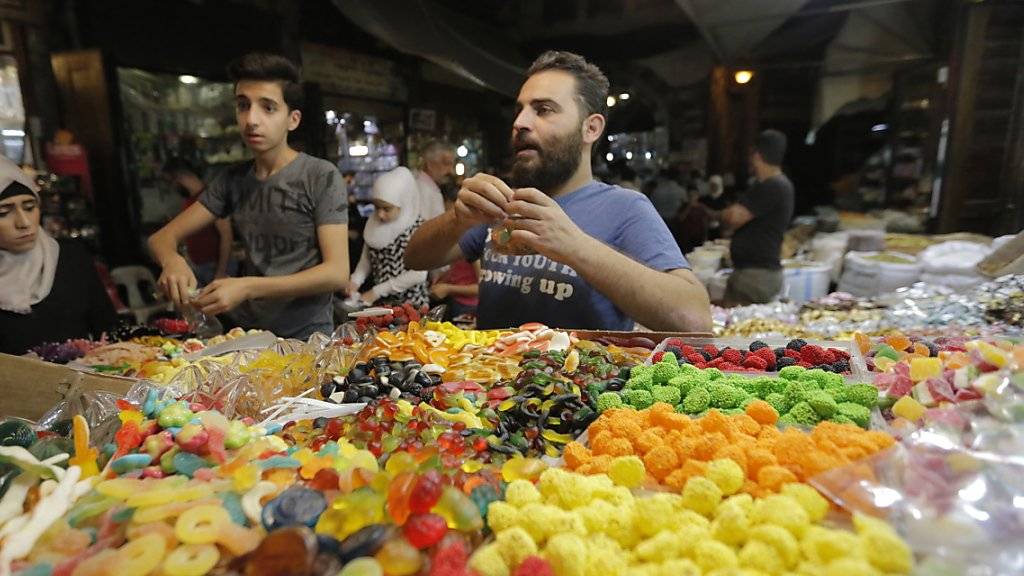 Die Menschen in Syrien decken sich auf einem Markt in Damaskus mit Süssigkeiten ein für Eid al-Fitr, das Fastenbrechen nach dem Ramadan.