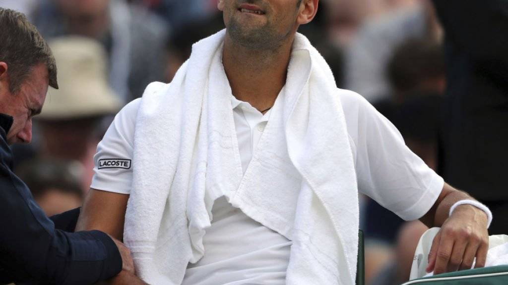 Schmerzhaft: Novak Djokovic lässt sich in Wimbledon den lädierten rechten Ellbogen pflegen