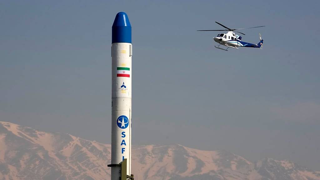 ARCHIV - Ein Hubschrauber fliegt über einen iranischen Satellitenträger. Foto: Vahid Salemi/AP/dpa