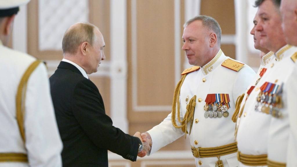ARCHIV - Der russische Präsident Wladimir Putin (l) schüttelt die Hände von russischen Marineoffizieren während seines Besuchs in St. Petersburg am Tag der Kriegsmarine. Foto: Alexei Danichev/Pool Sputnik Kremlin/AP/dpa