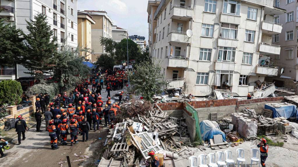 Feuerwehrleute und Rettungskräfte sind an einem eingestürzten mehrstöckigen Gebäude im Einsatz. Foto: Abdullah Tepeli/Dia Photo/AP/dpa
