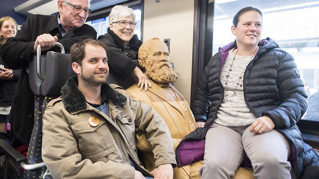 Die Schweiz ist eine Nation von Bahnfahrenden. Passagiere posieren mit einer Statue des Eisenbahnpioniers Alfred Escher. (Archivbild)