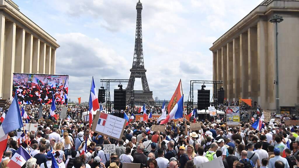 Demonstranten nehmen in Paris an einem Protest gegen die verschärften Corona-Regeln teil. Foto: Alain Jocard/AFP/dpa